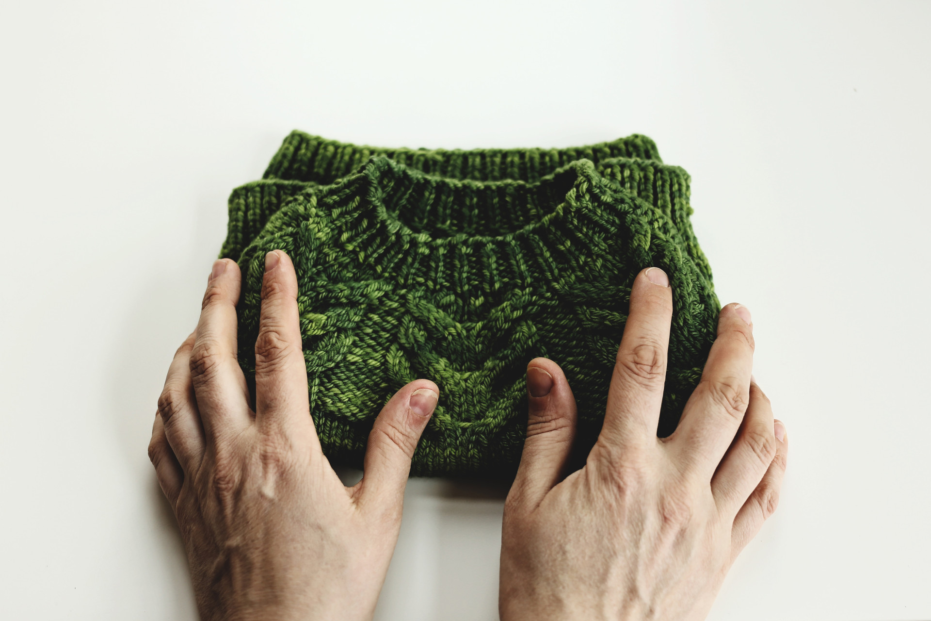 Image of hands touching a finished knitted jumper